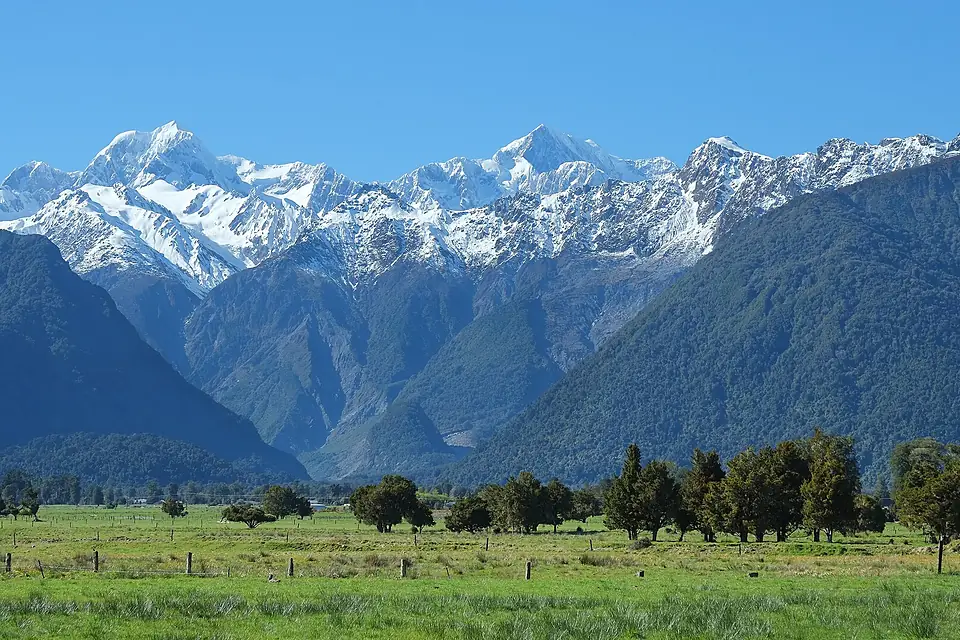 Fox Valley entrance with Mount Tasman and Aoraki Mount Cook behind and paddocks in front